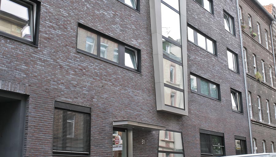 Klinker-Wohnhaus mit einem Erker aus Aluminiumfenstern.